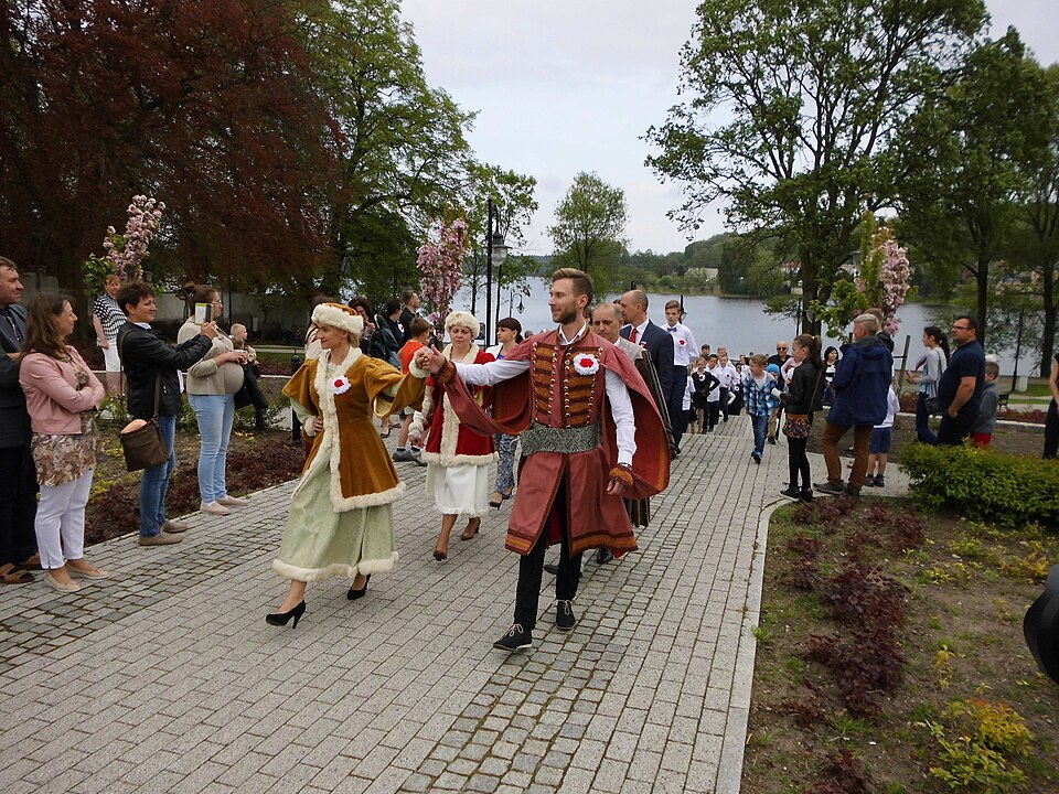 Tancerze w strojach ludowych idący w polonezie